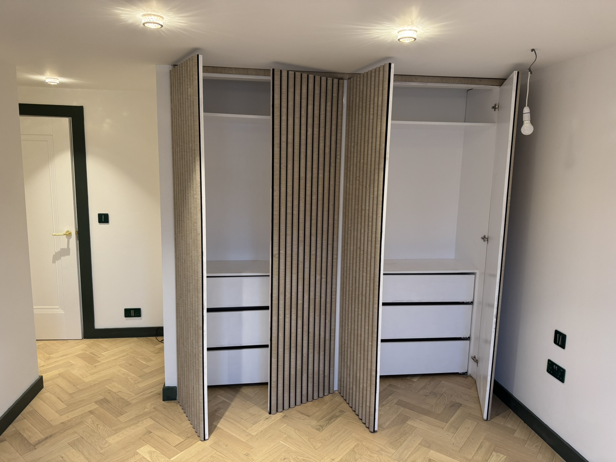 Fitted wardrobe with slatted wood-effect doors, open
