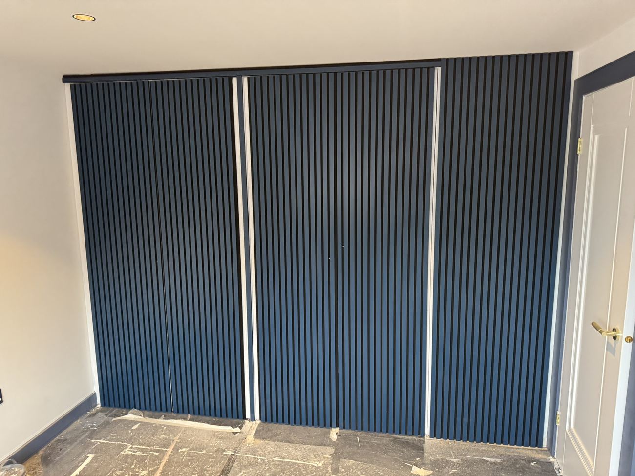 Built-in wardrobes with navy slatted doors