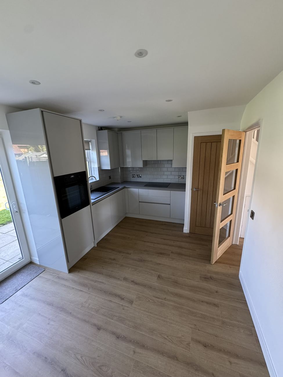 Open-plan kitchen with oak glazed door