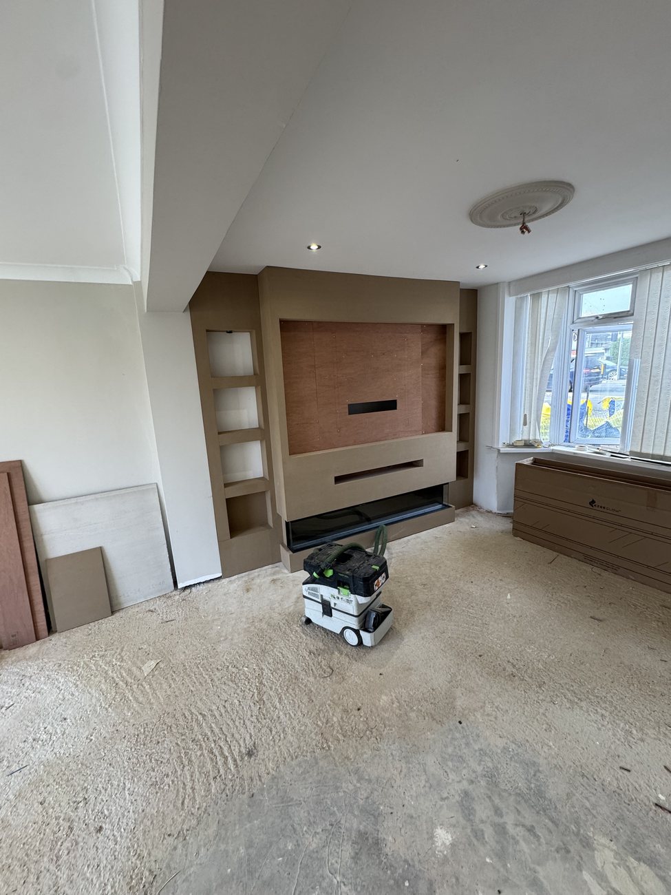 Media wall with alcoves being built in a living room