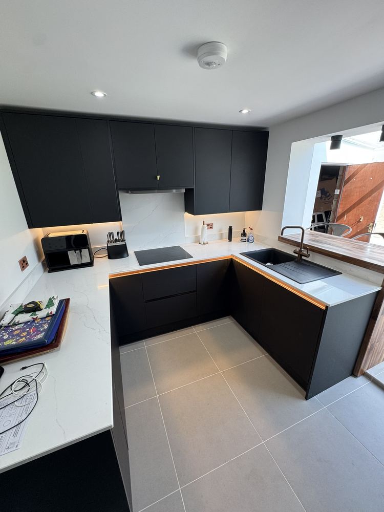 Matt black fitted kitchen with white worktops